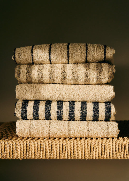 Stack of five linen-cotton blend towels with wide indigo stripes and natural cooling effect.