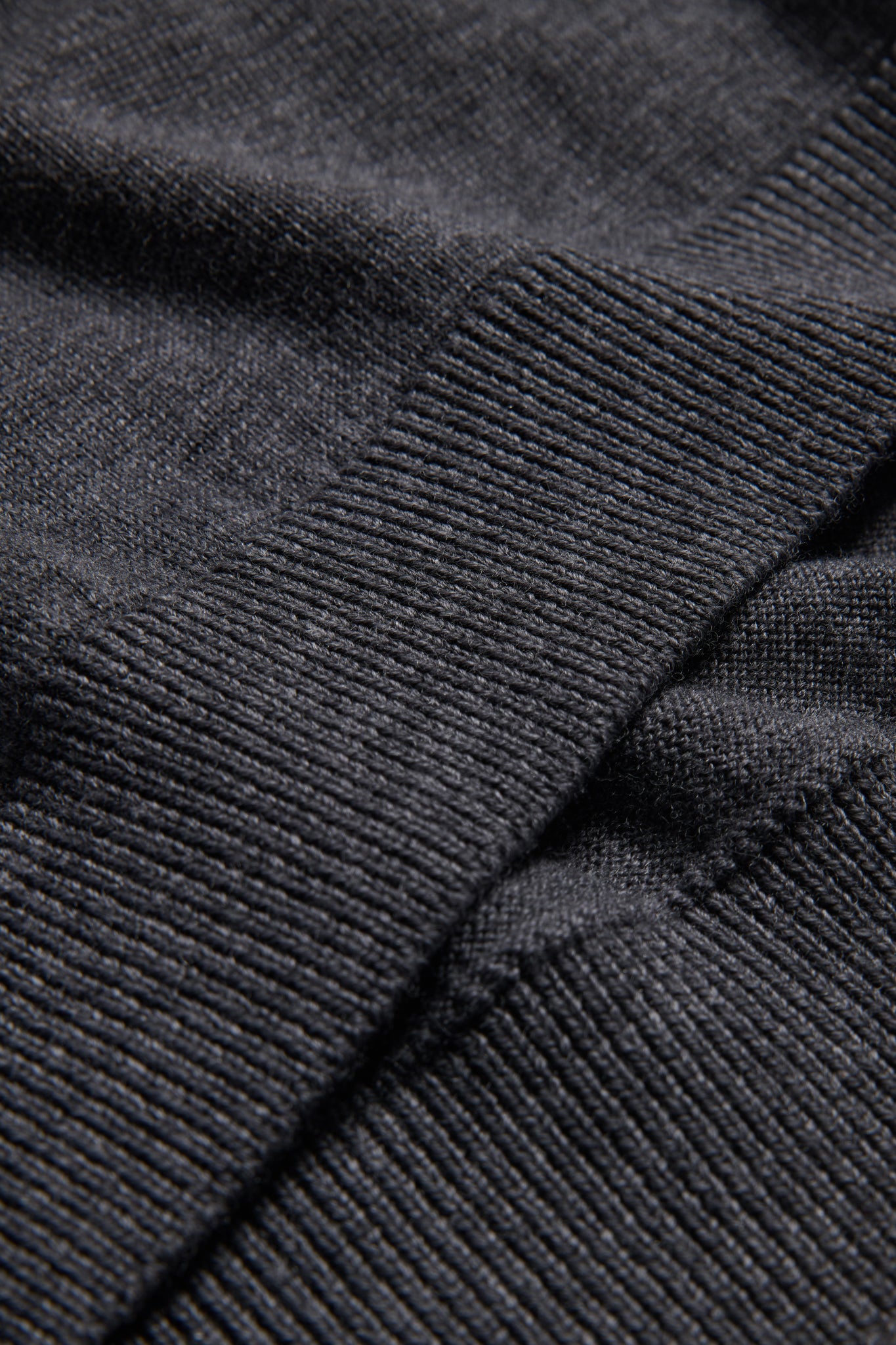 Unisex knit crewneck, dark-grey mulesing-free merino wool, showing rib-knit texture on cuffs and hem.
