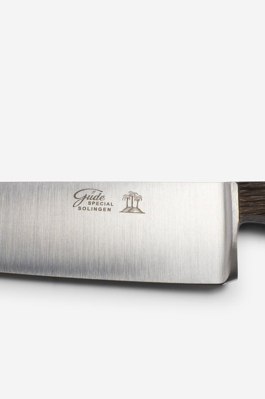 Chef's knife with a brushed steel blade featuring "Gude Special Solingen" and a palm tree logo, and a dark bog oak handle.