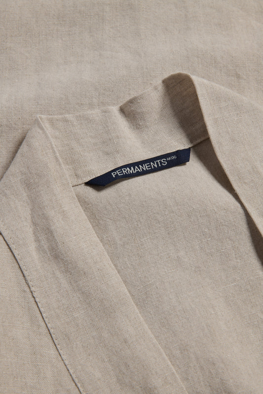 Unisex outerwear bathrobe, 100% Belgian flax linen, natural beige, with a dark blue "PERMANENTS" brand label.