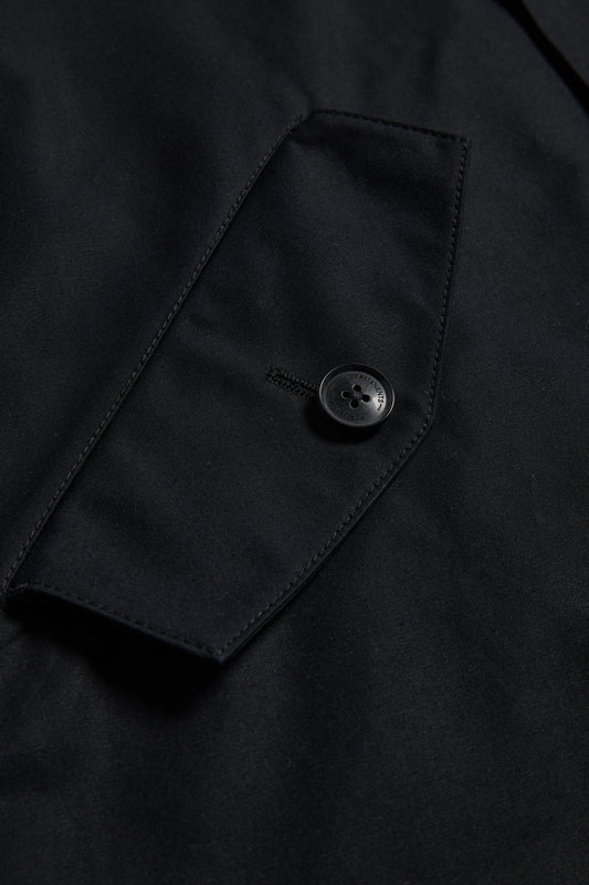 Unisex outerwear parka, black organic cotton EtaProof fabric, close-up of flap pocket with button.
