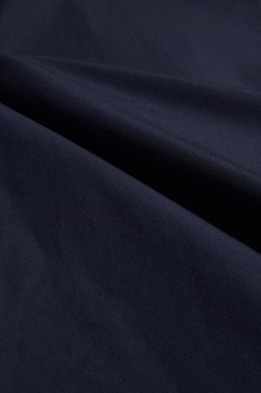 Navy organic Swiss EtaProof® cotton fabric, densely woven and waterproof, with soft folds.