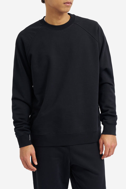 Men's knit sweater, 100% organic cotton, pre-washed, black, with raglan sleeves and subtle logo.