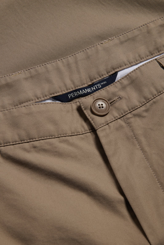Men's long-pants, organic cotton twill, washed beige, with button closure and "PERMANENTS" label.