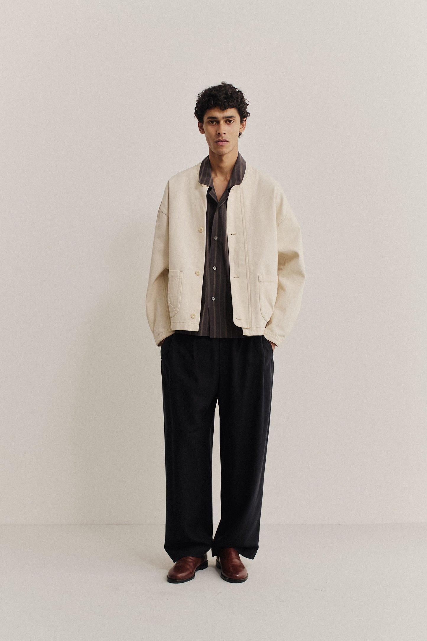 Men's outerwear jacket, organic cotton raw denim, off-white, boxy fit, stand-up collar, patch pockets.
