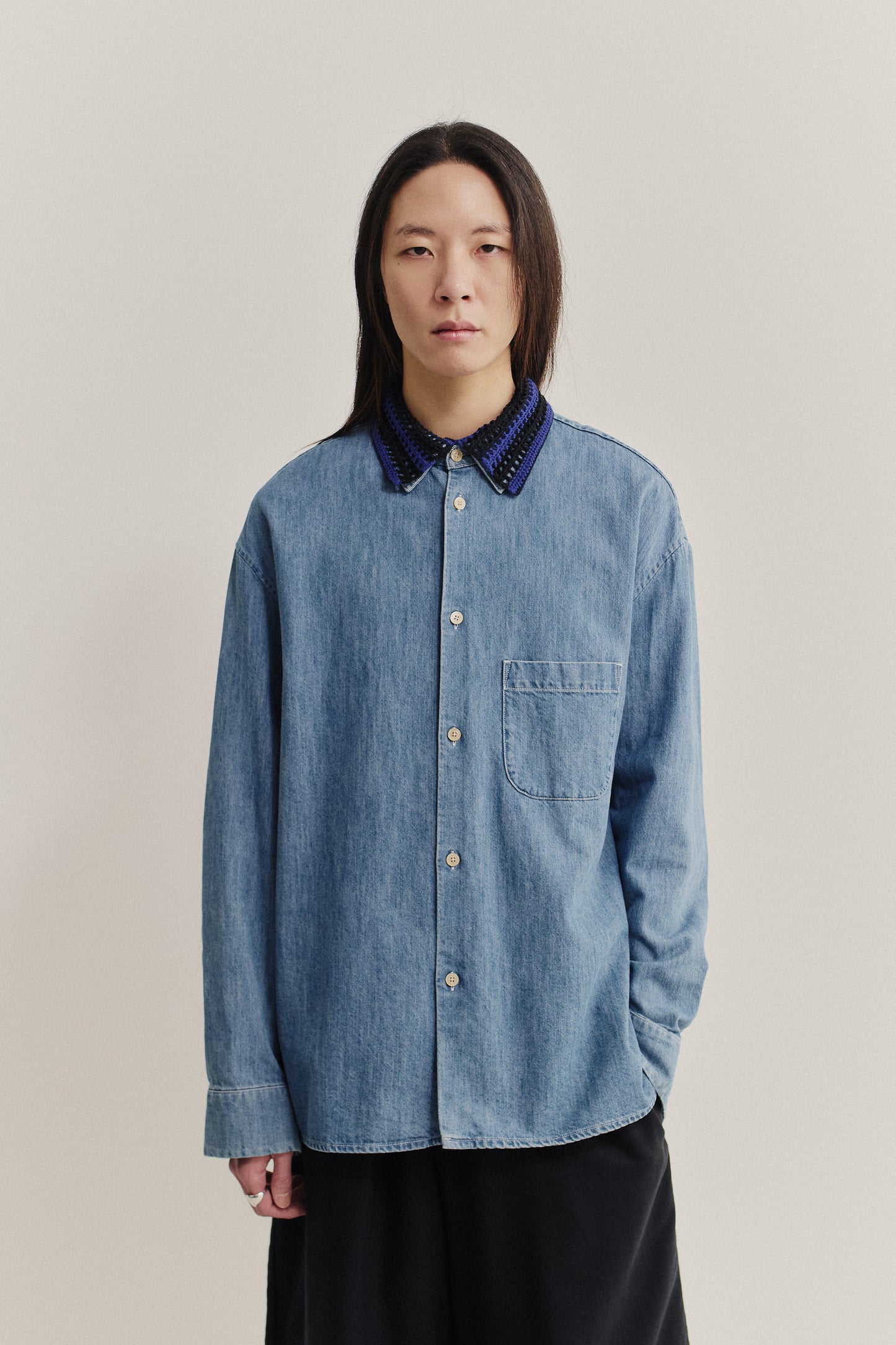 Women's accessories, hand-crocheted Kikoy Collar in blue and black merino wool, worn over a denim shirt.