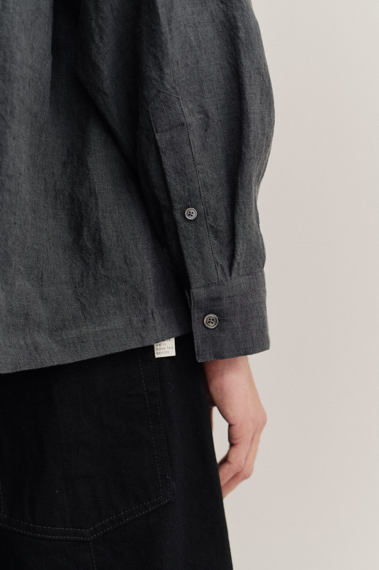 Men's long-sleeved shirt, 100% linen, vintage-like texture, dark grey, with buttoned cuffs.