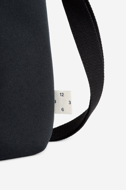 Unisex accessories bag, recycled cotton, black, with a white fabric tag showing numbers 12, 3, 6.