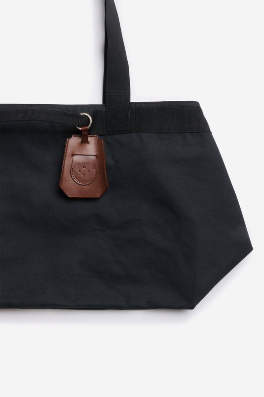 Accessories key chain, vegetable-tanned leather, brown, attached to a black tote bag.