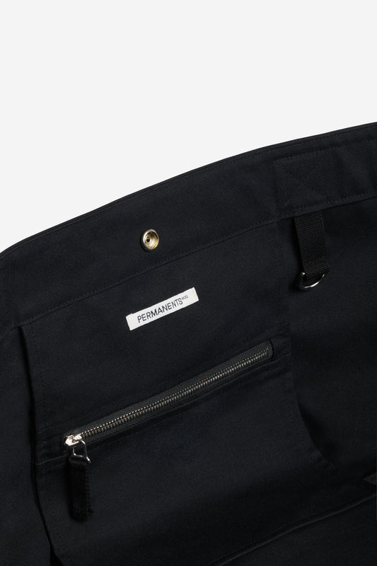 Accessories carryall bag, black recycled Ventile cotton, with interior zip pocket and "PERMANENTS" label.
