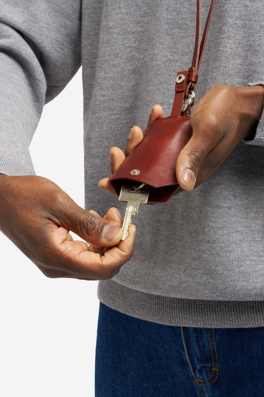 men accessories key chain, vegetable-tanned leather, brown, holding a key.