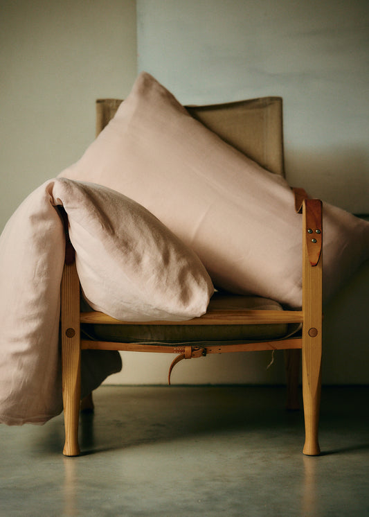 Pillowcase 80x80, 100% Belgian linen, apple blossom pink, with zipper closure, on a wooden chair.