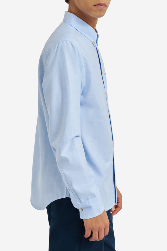 Men's long-sleeved shirt, light blue organic cotton, with button cuffs and pocket detail.