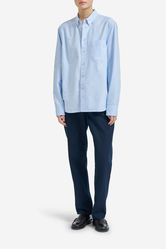 Men's long-sleeved shirt, light blue organic cotton, with pocket detail and pearl buttons.
