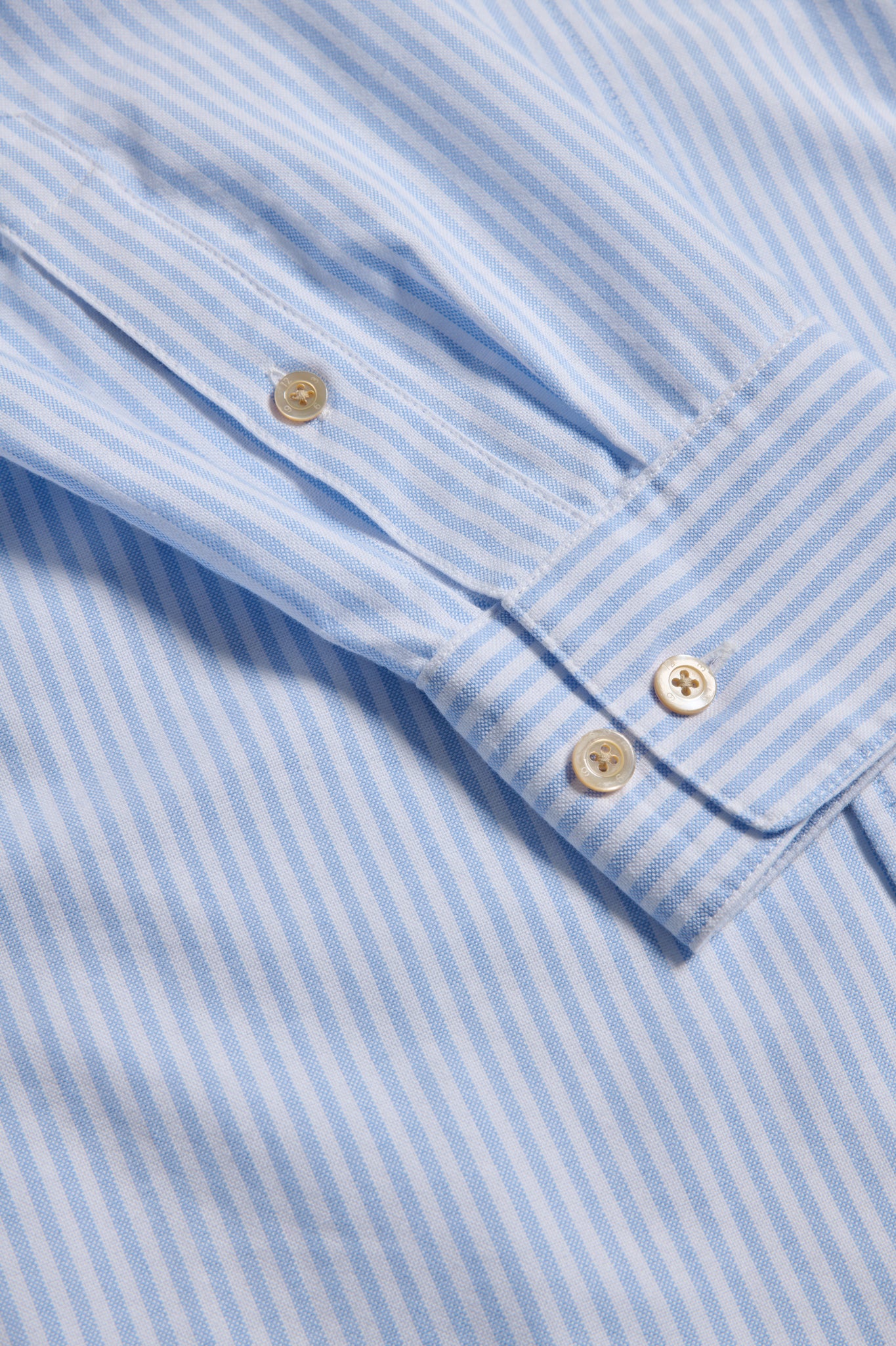 Unisex long-sleeved shirt, organic cotton, fine stripes, light blue and white, with pearl buttons.