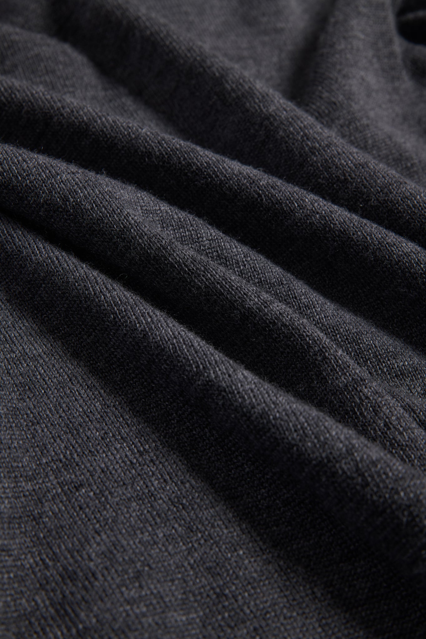 Unisex knit crewneck, dark-grey mulesing-free merino wool, finely knitted with visible rib-knit texture.