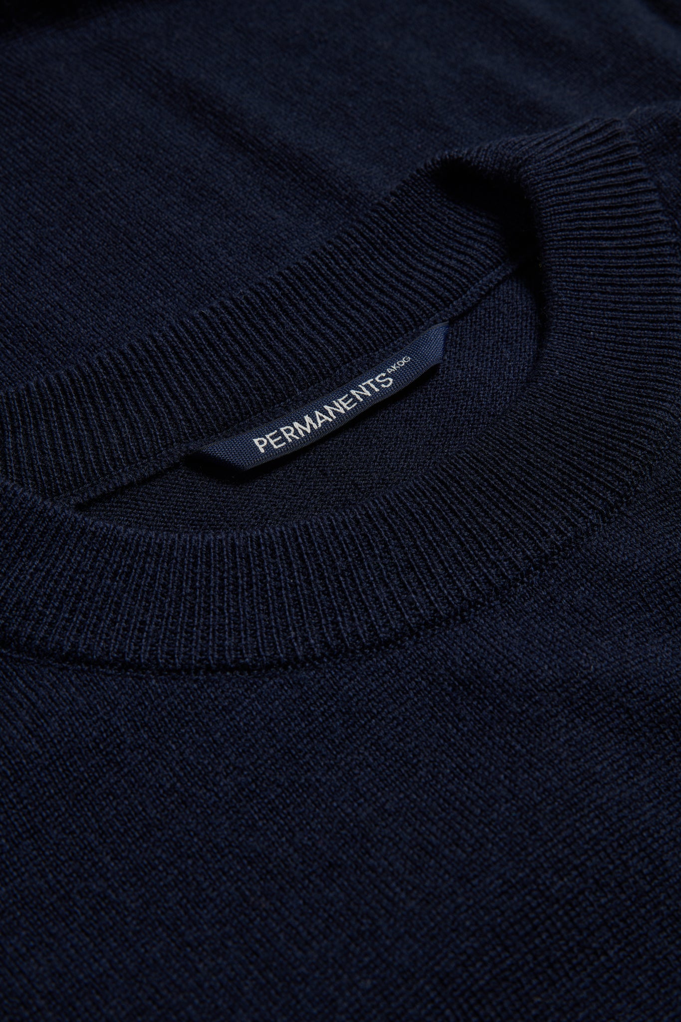 Unisex knit crewneck, 100% mulesing-free merino wool, navy, with rib-knit neck and PERMANENTS® label.