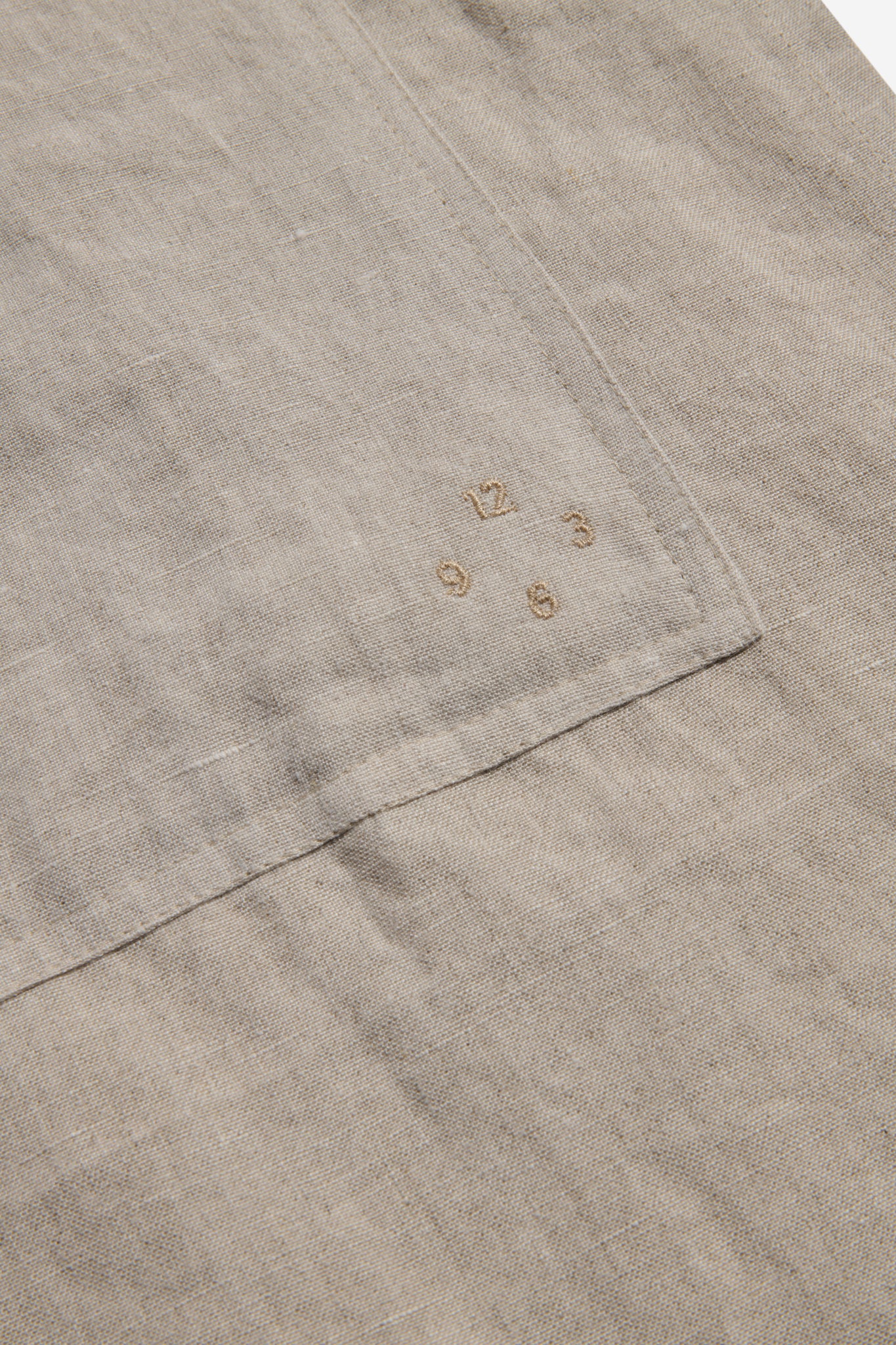 Unisex accessories apron, 100% Belgian linen, flax, with embroidered clock numbers on a patch pocket.