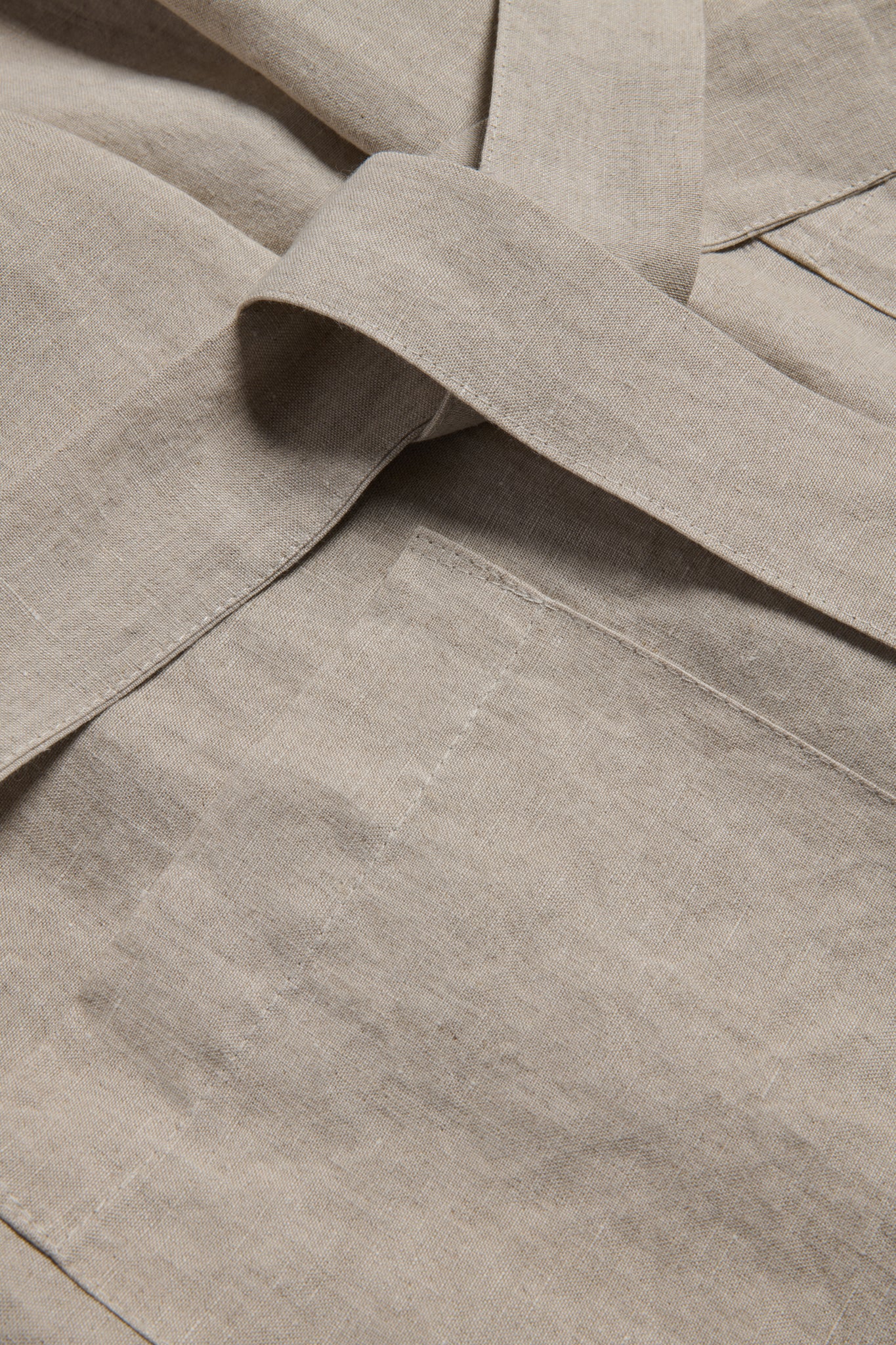 Unisex bathrobe, 100% Belgian linen, flax color, with a tied belt and patch pocket detail.