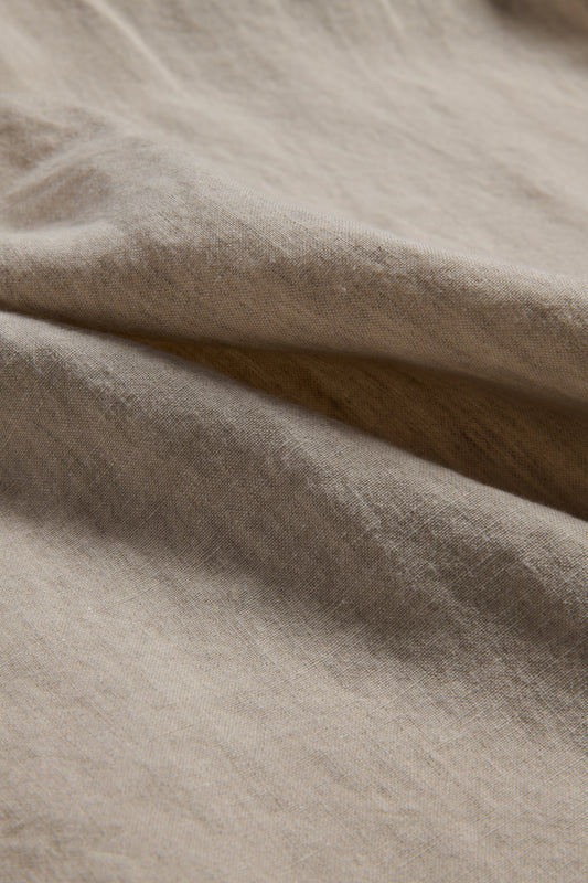 Unisex bathrobe, 100% Belgian linen, flax color, close-up of soft, draped fabric.