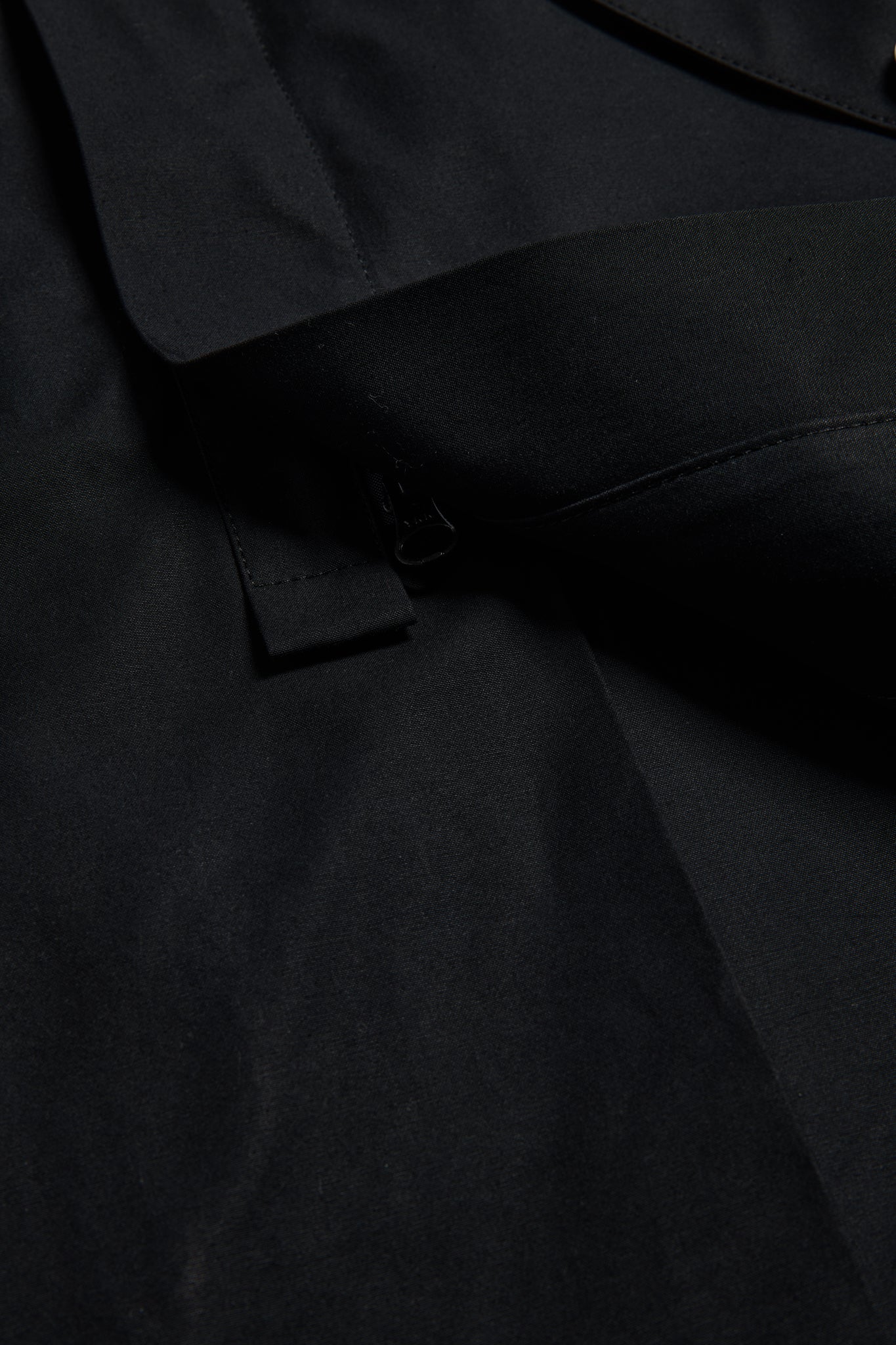Men's outerwear parka, black organic cotton EtaProof® fabric, close-up of collar and zipper.