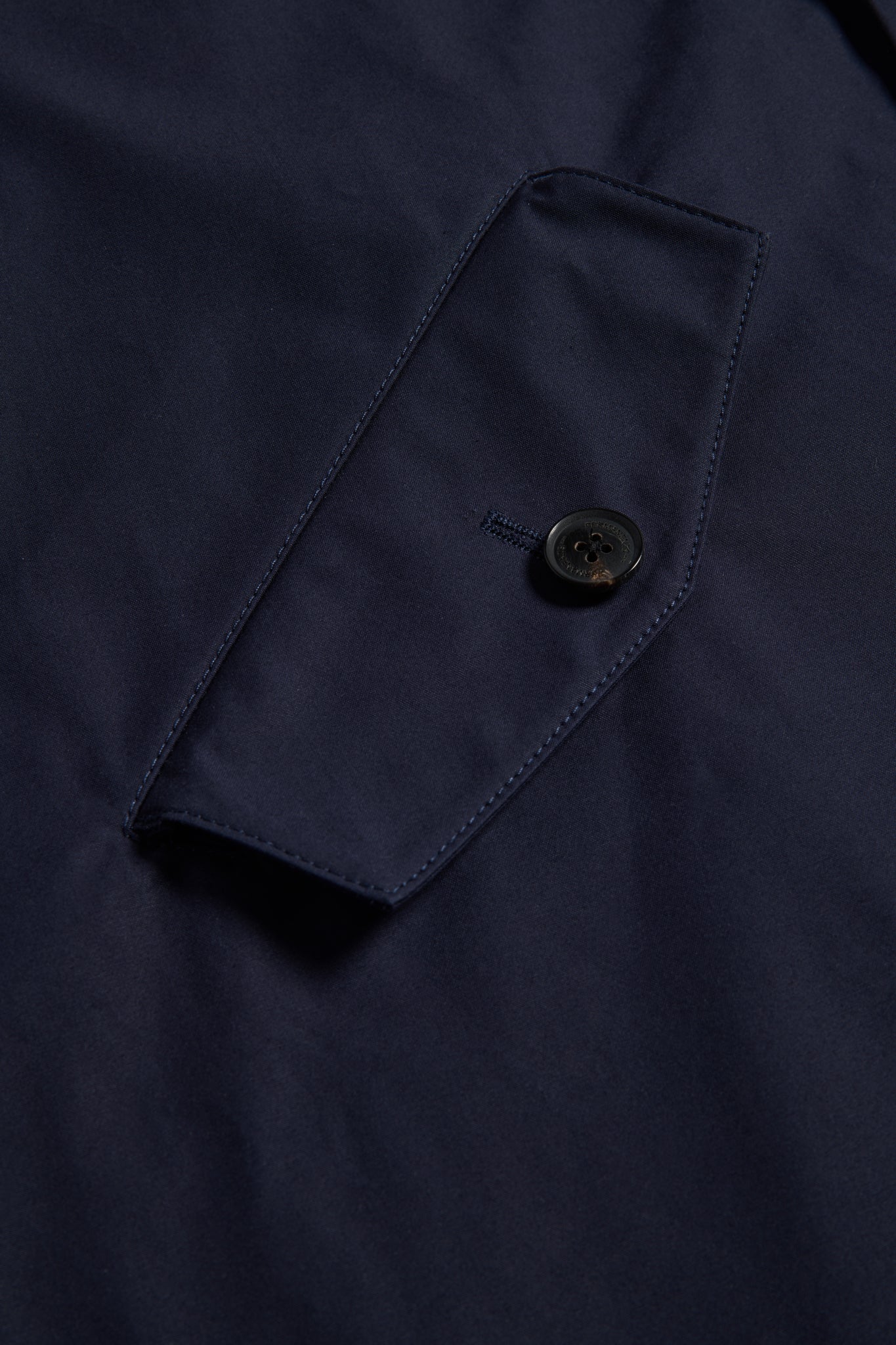 Men's outerwear parka, navy organic cotton EtaProof® fabric, close-up of flap pocket with button.