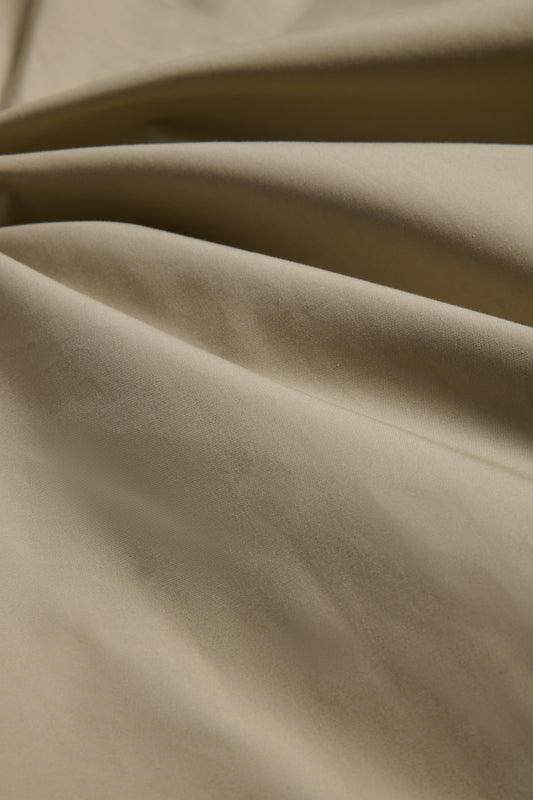 Outerwear parka, stone organic cotton EtaProof® fabric, showing dense weave and subtle folds.