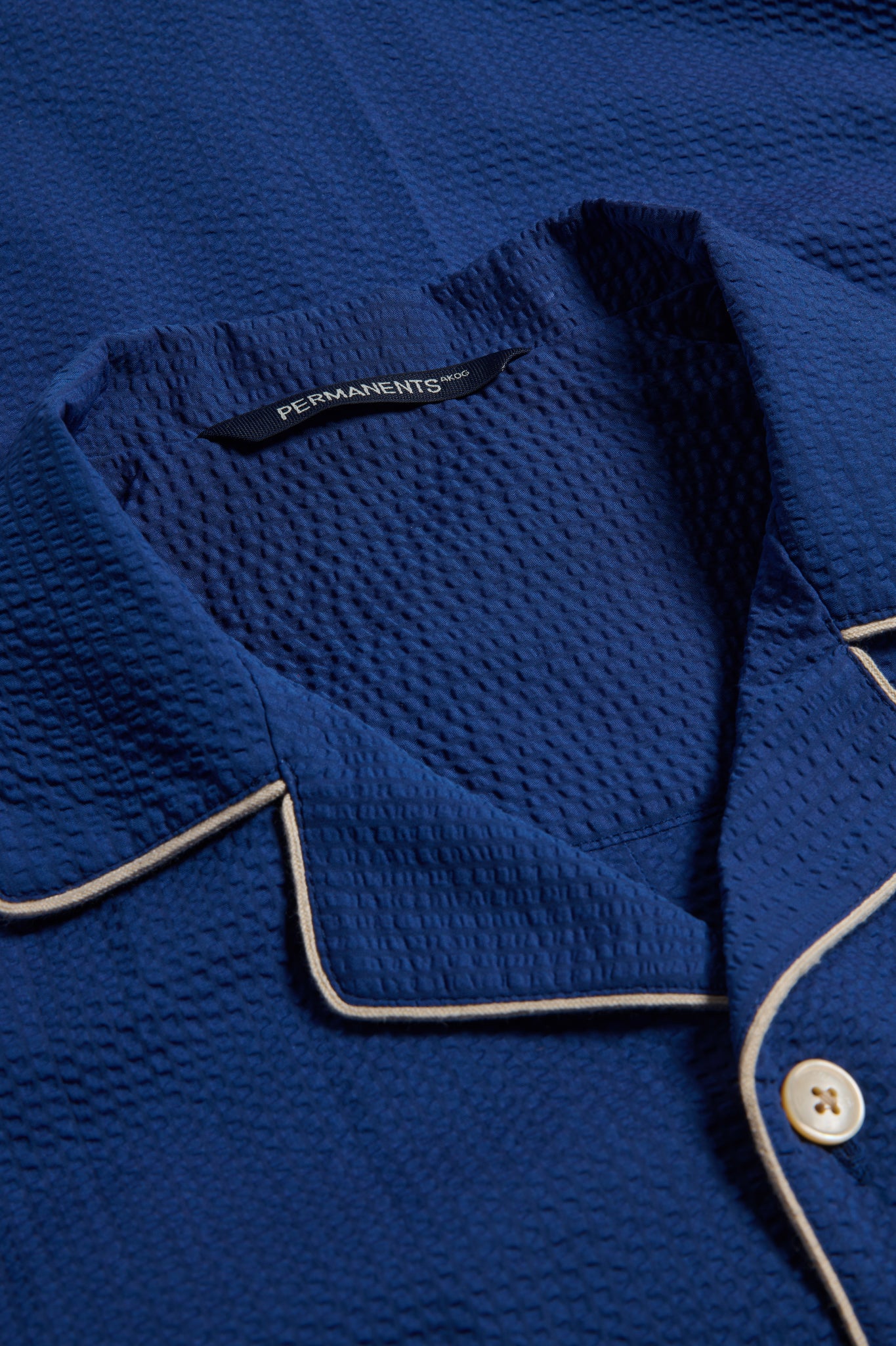 Unisex long-sleeved shirt, 100% organic cotton seersucker, blue hour, with piped trim and light buttons.