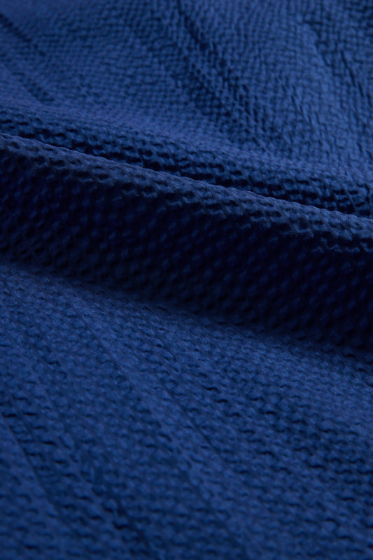 Unisex pyjama set, organic cotton seersucker, blue hour, close-up of textured fabric.