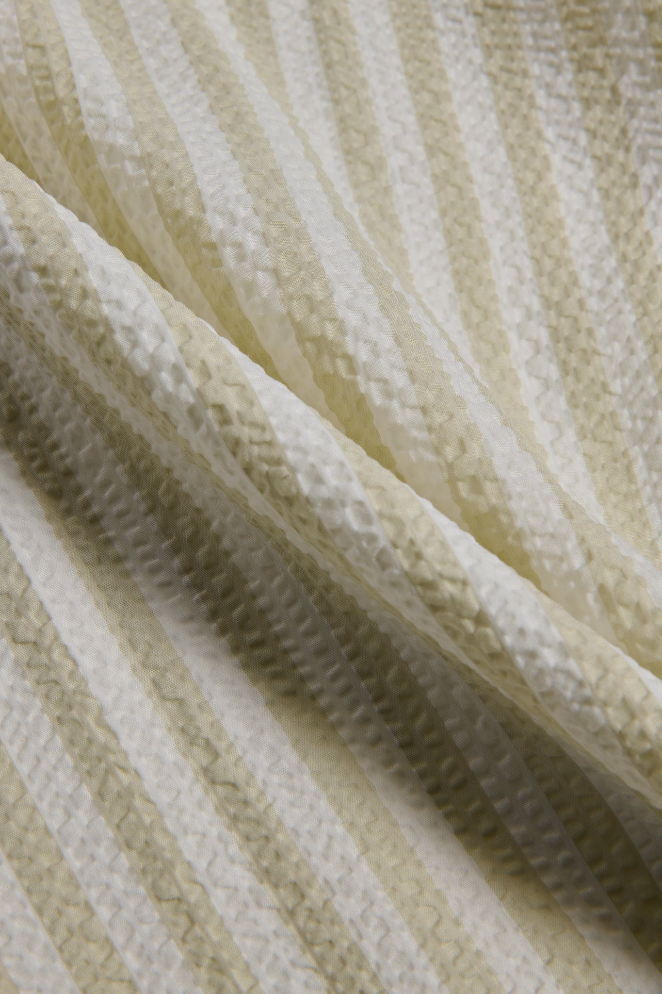 Unisex pyjama set, 100% organic cotton seersucker, sage stripe, close-up of fabric texture.