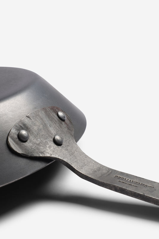 Dark grey wrought iron pan with an embossed logo on the handle, 28cm diameter.