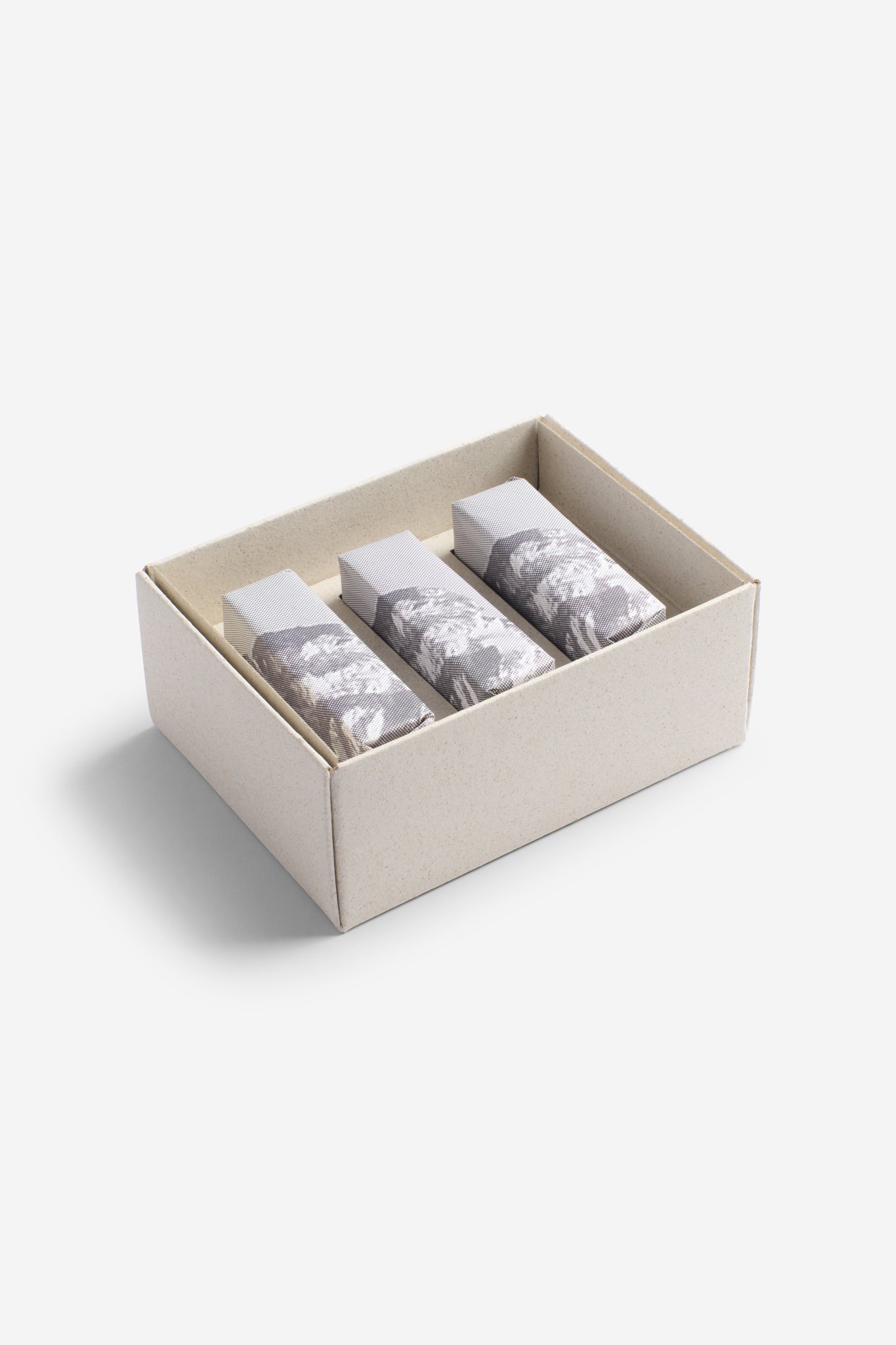 Accessories set of 3 soap bars, individually wrapped in grey and white patterned paper, in a natural cardboard box.
