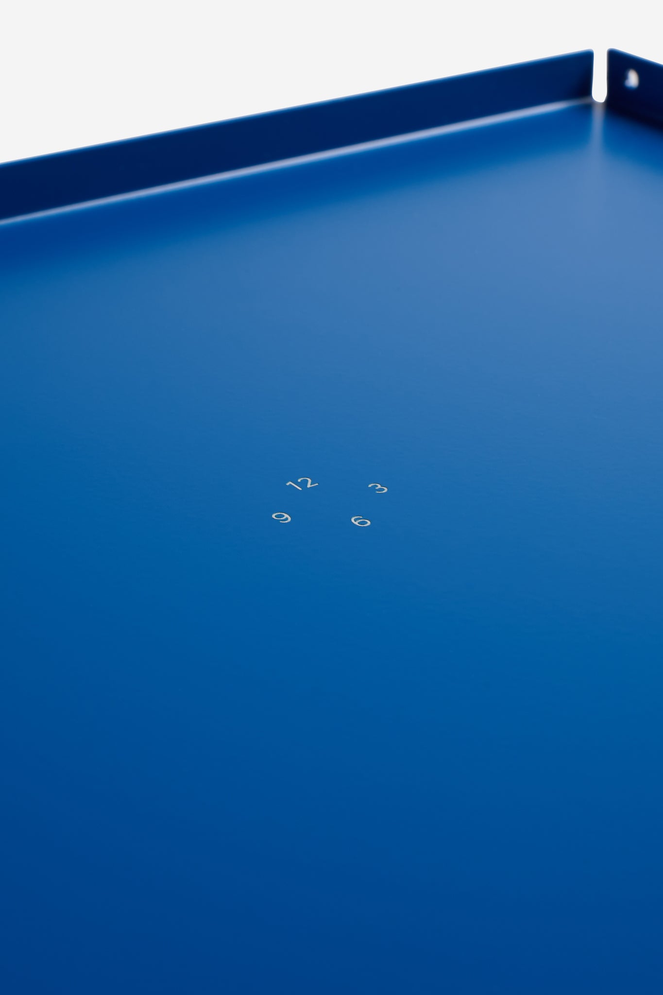 Accessories tray, single piece gentian coated aluminum, 34x26cm, with subtle white numbers.