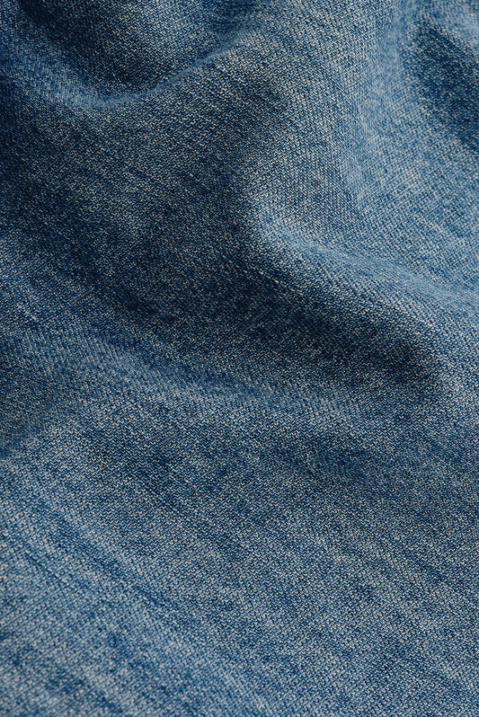 Men's long-sleeved shirt, light blue organic cotton, viscose, and silk denim fabric with vintage-inspired texture.
