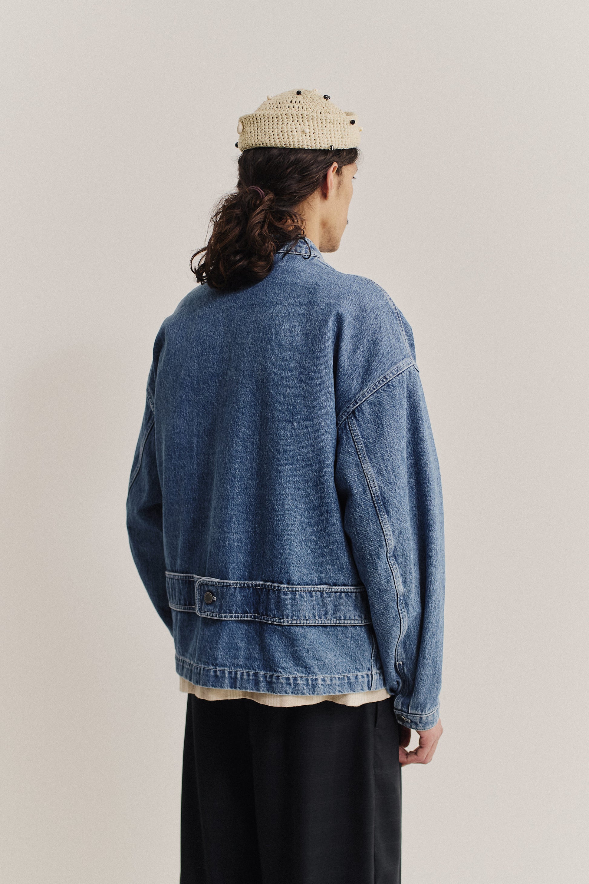 Men's outerwear denim jacket, stone washed blue, with dropped shoulders and back strap detail.