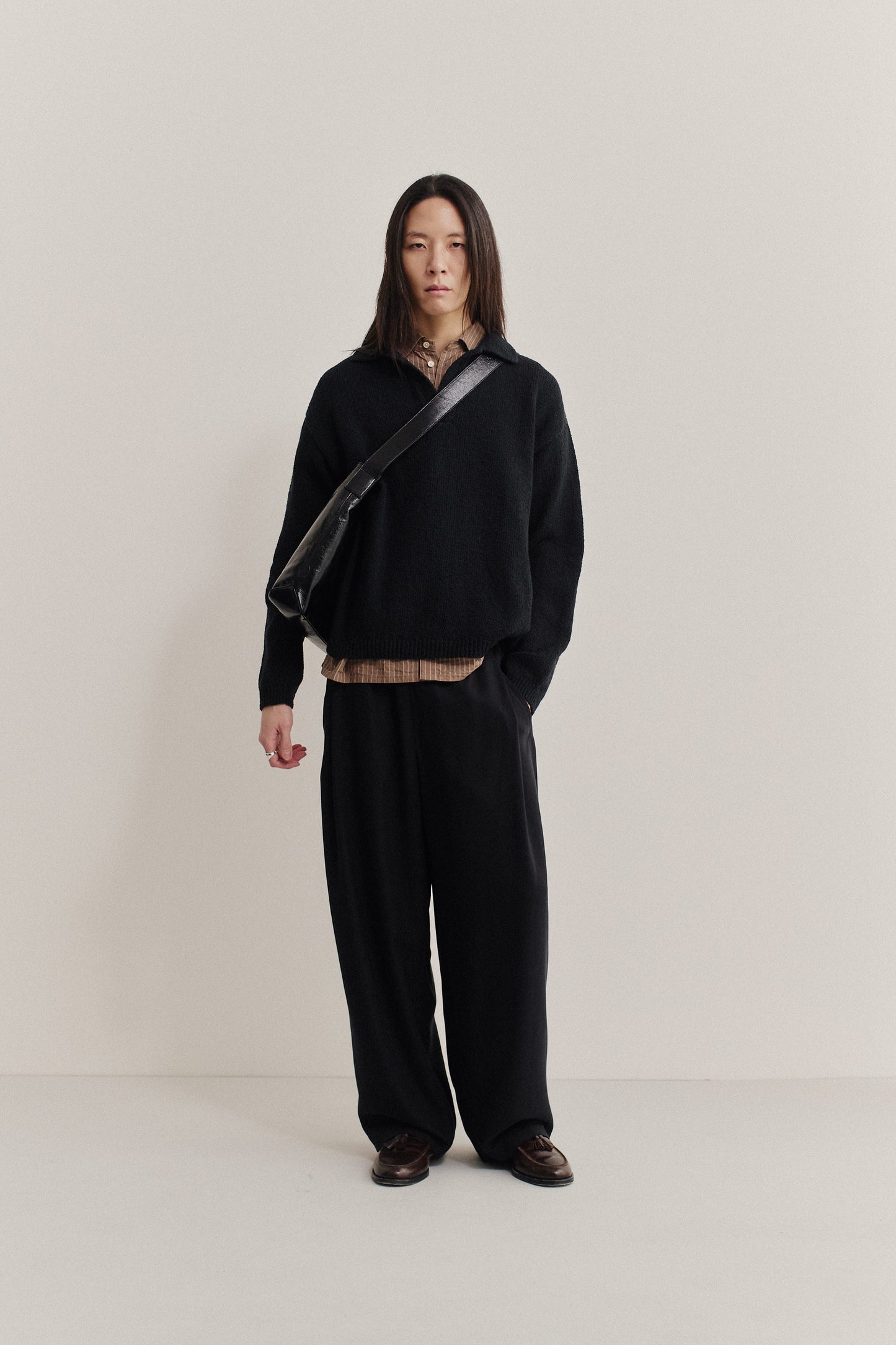 Men's knit, long-sleeved, black organic cotton bouclé polo with dropped shoulders and relaxed fit.