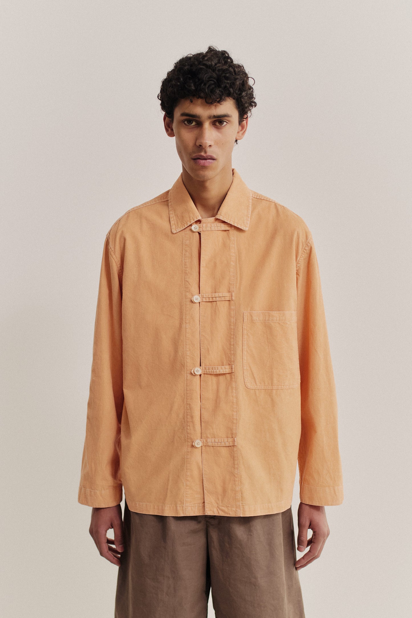 Men's long-sleeved overshirt, light corduroy cotton, garment washed, peach, with front patch pocket and button fastening.