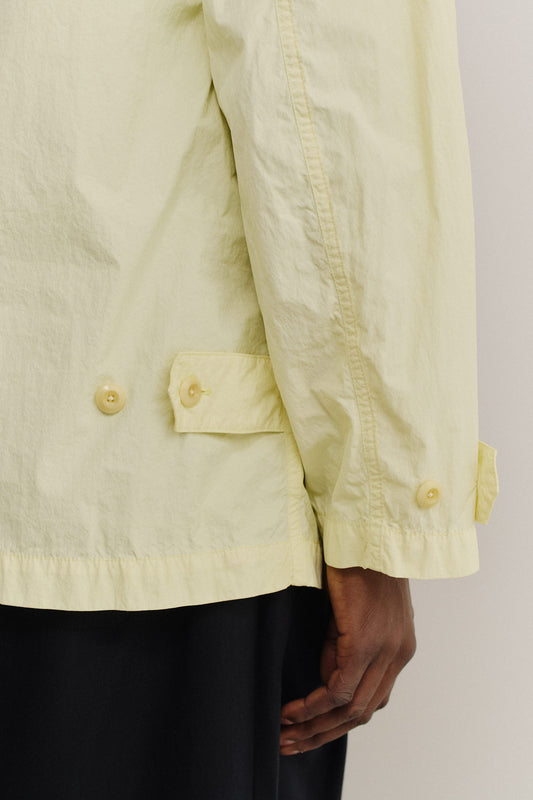 Men's outerwear jacket, recycled polyamide, garment-dyed washed light yellow, with corozo buttons and patch pockets.