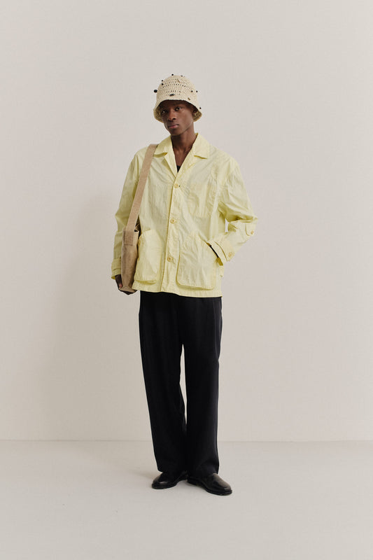 Men's outerwear jacket, recycled polyamide, garment-dyed washed light yellow, with vintage lapel and patch pockets.