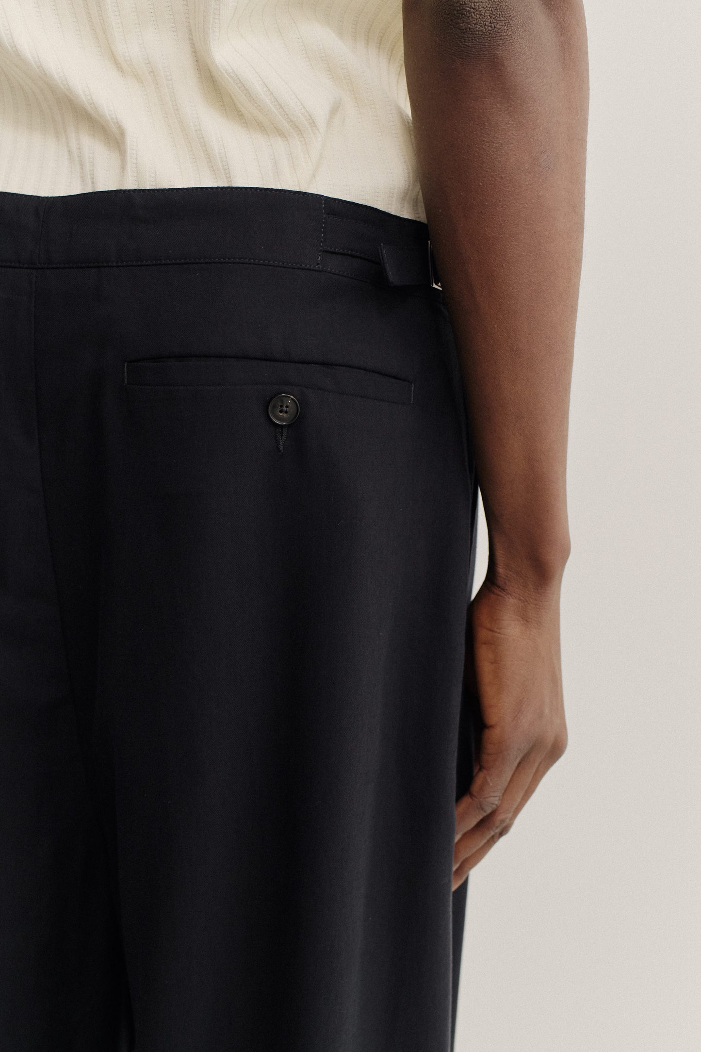 Men's pants, long-pants, lyocell twill, black, with back welt pocket and button closure.