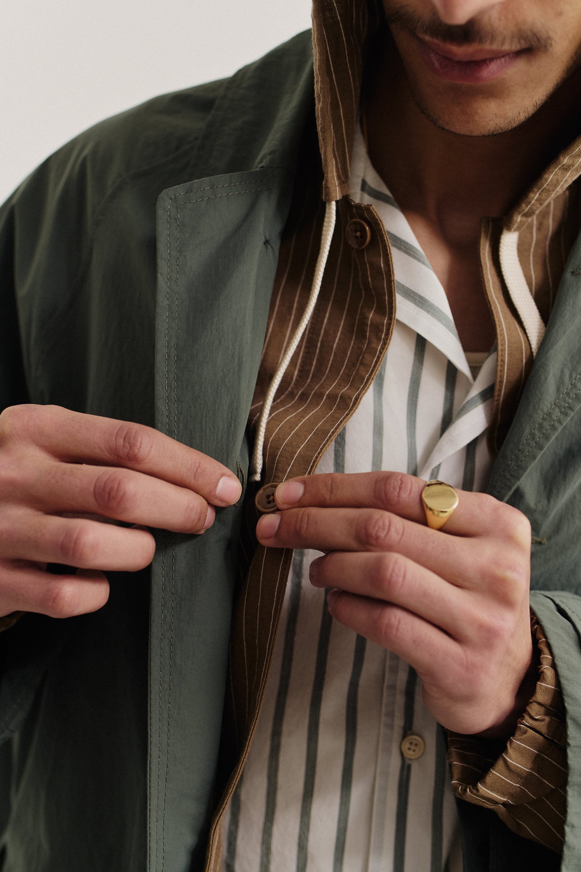 Men's outerwear, oversized Serrara Mac in water-repellent recycled nylon and cotton blend, olive green, with deconstructed silhouette and reverse collar.