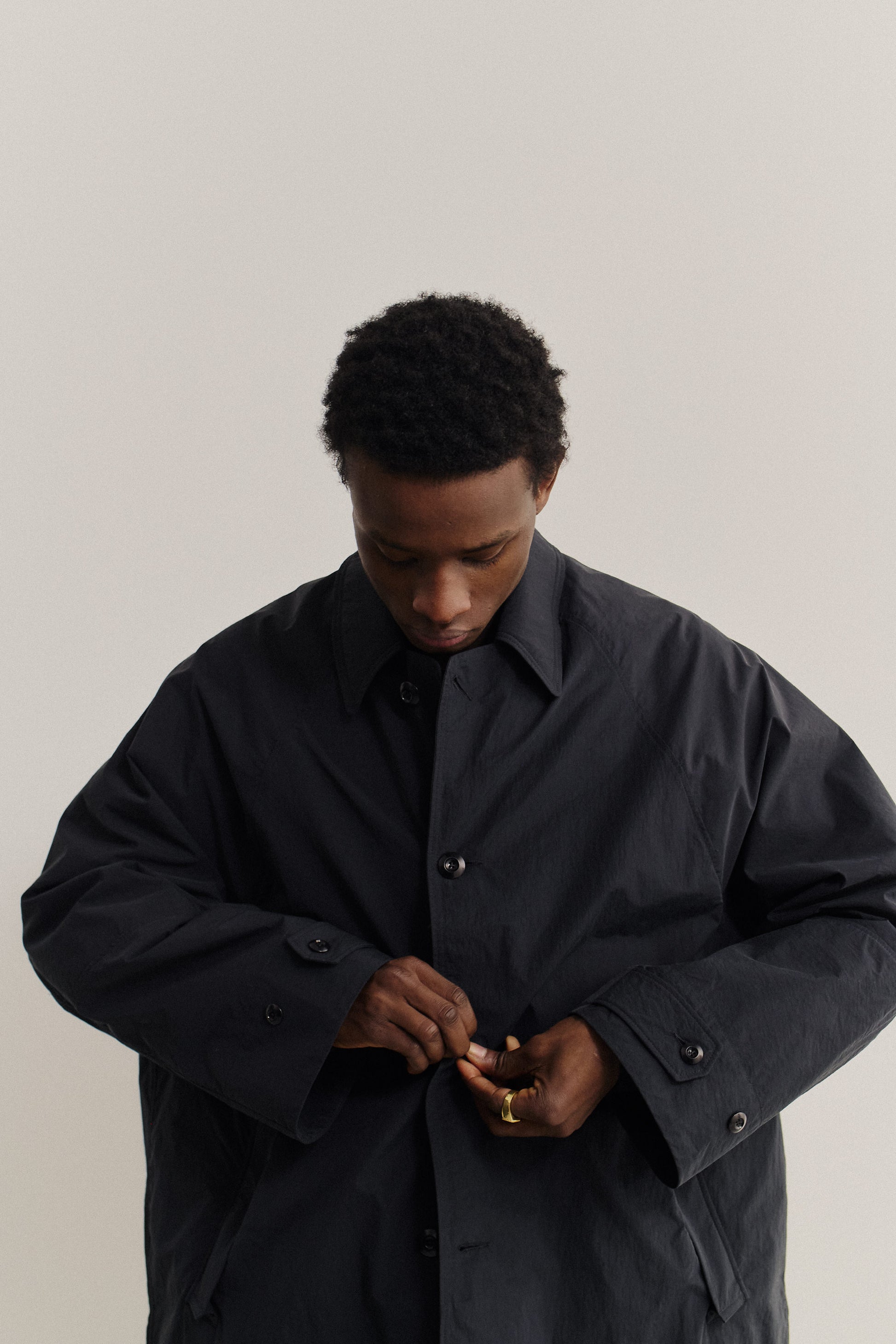 Men's outerwear, oversized black recycled nylon-cotton blend Serrara Mac jacket with reverse collar and button closure.