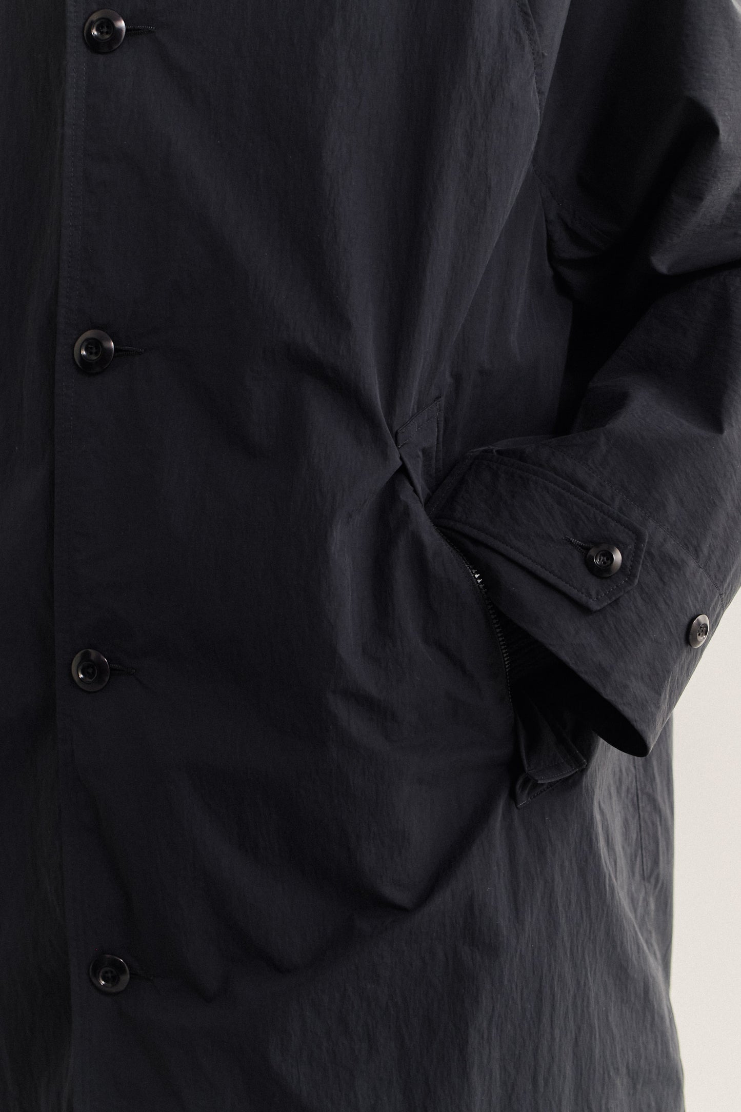 Men's outerwear, oversized Serrara Mac in black recycled nylon and cotton blend, water-repellent, with button closure and zipped welt pocket.