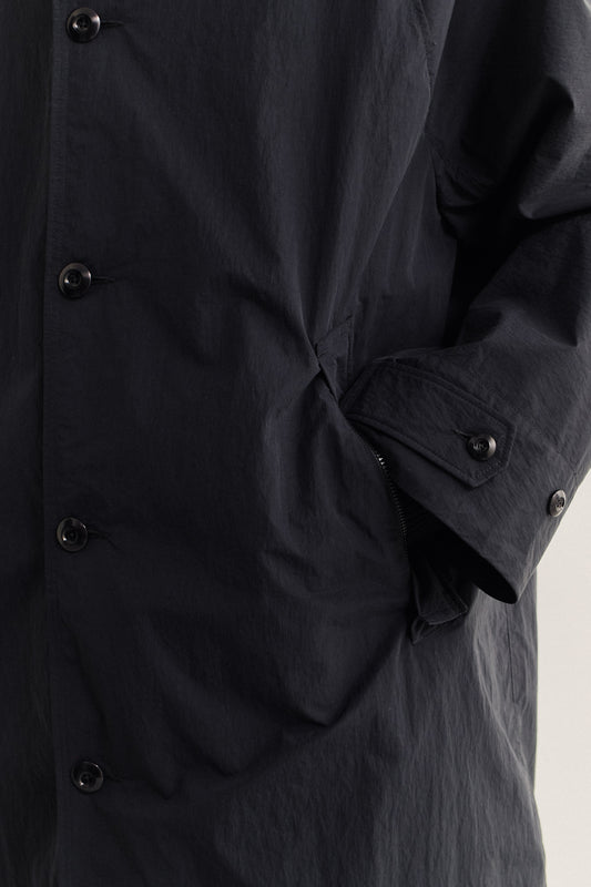 Men's outerwear, oversized Serrara Mac in black recycled nylon and cotton blend, water-repellent, with button closure and zipped welt pocket.