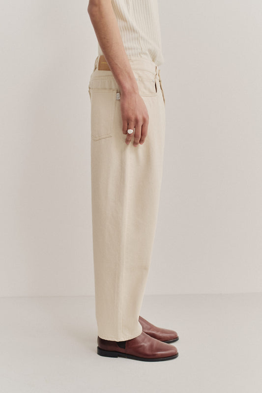 Men's long-pants, organic cotton raw denim, off-white, loose fit, tapered leg, cropped length.