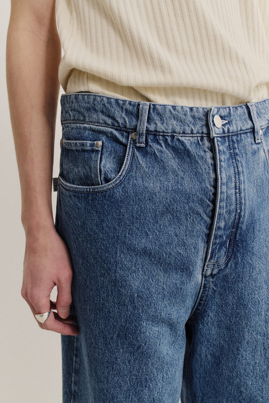 Men's long-pants, cotton mix denim, stone washed mid-blue, with a loose fit and tapered leg.