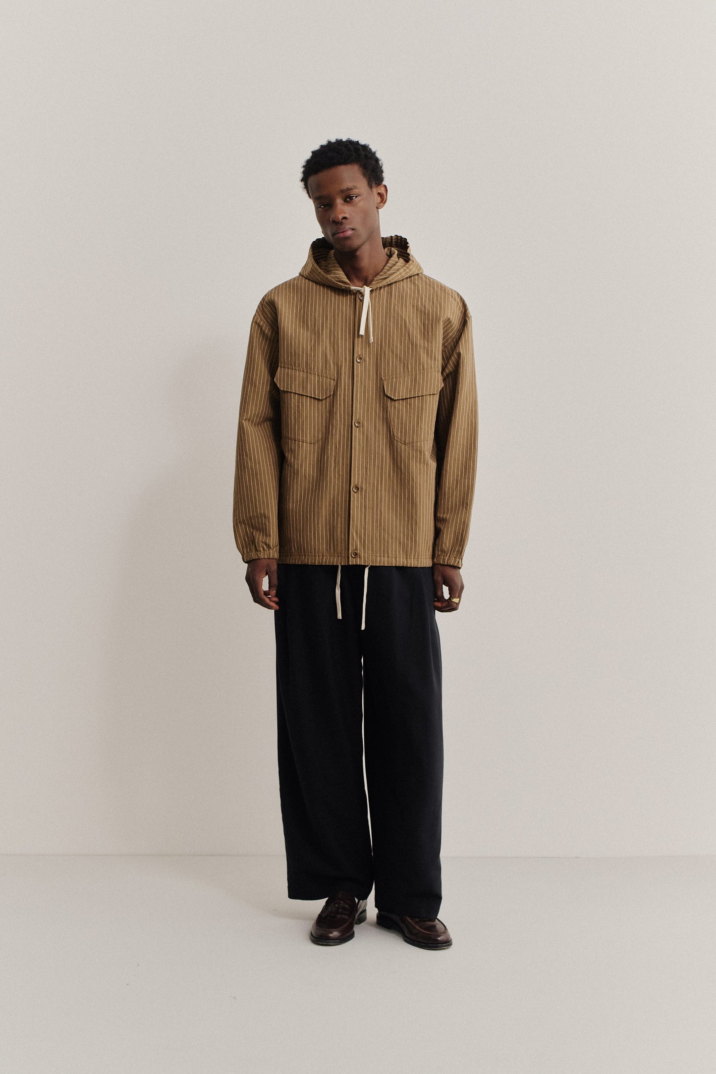 Men's outerwear jacket, cotton-linen seersucker, pinstriped brown, with hood and front pockets.