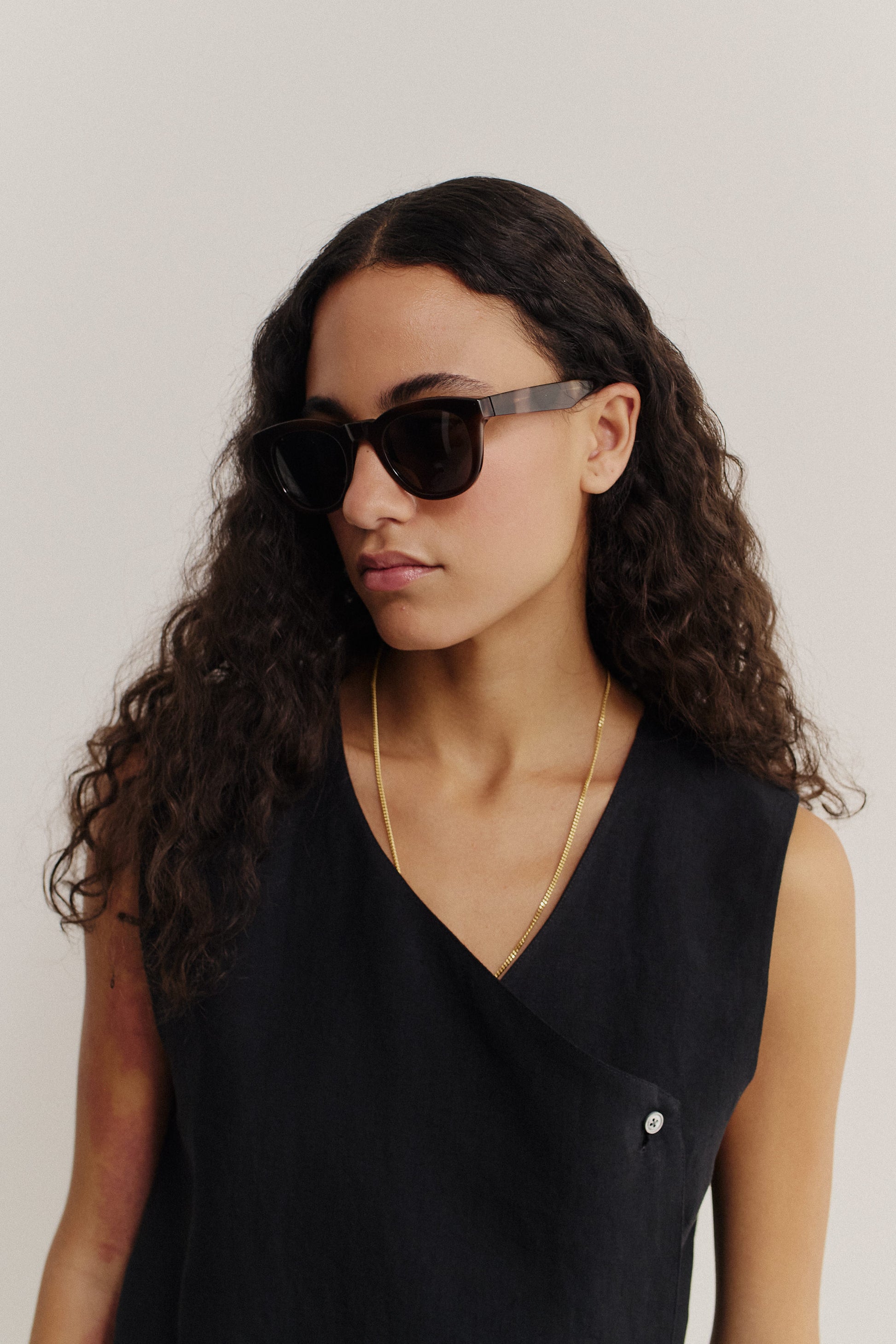 Women's accessories, dark brown round acetate sunglasses with keyhole bridge, black lenses, and gold chain.