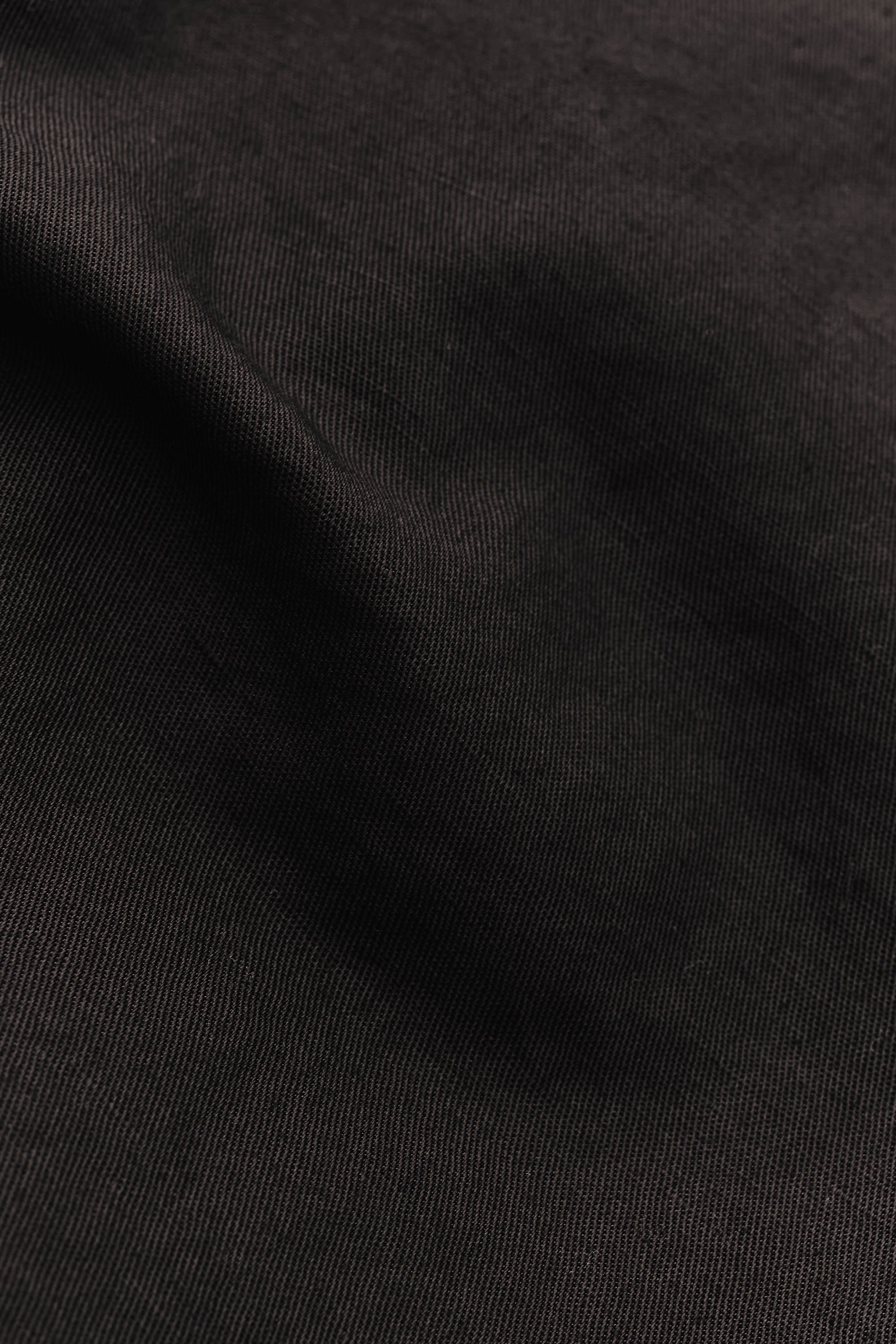Men's long-pants, linen and cotton blend, garment-dyed deep black with textured surface.