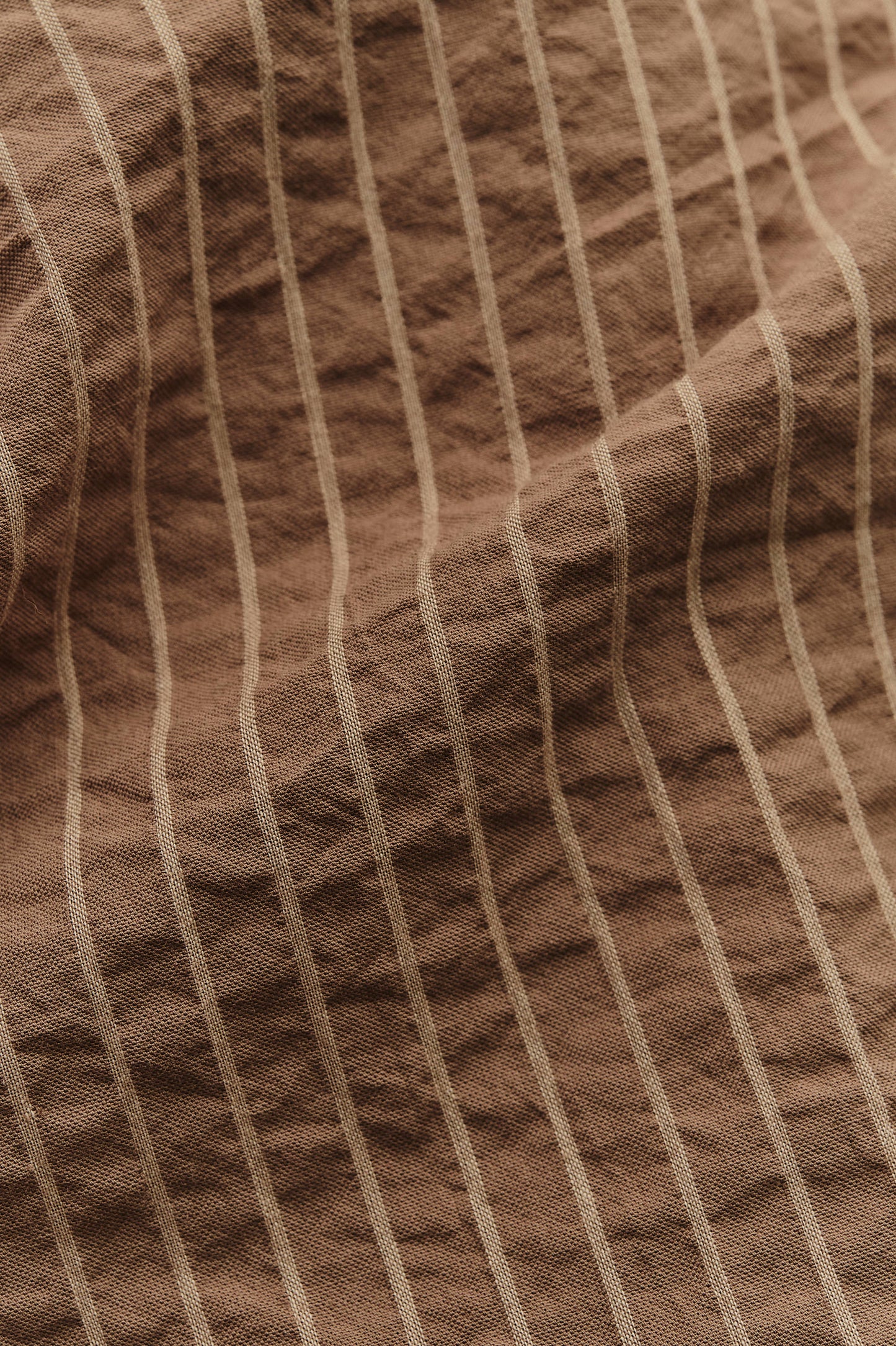 Men's short-sleeved shirt, organic cotton seersucker, cocoa brown with light stripes.